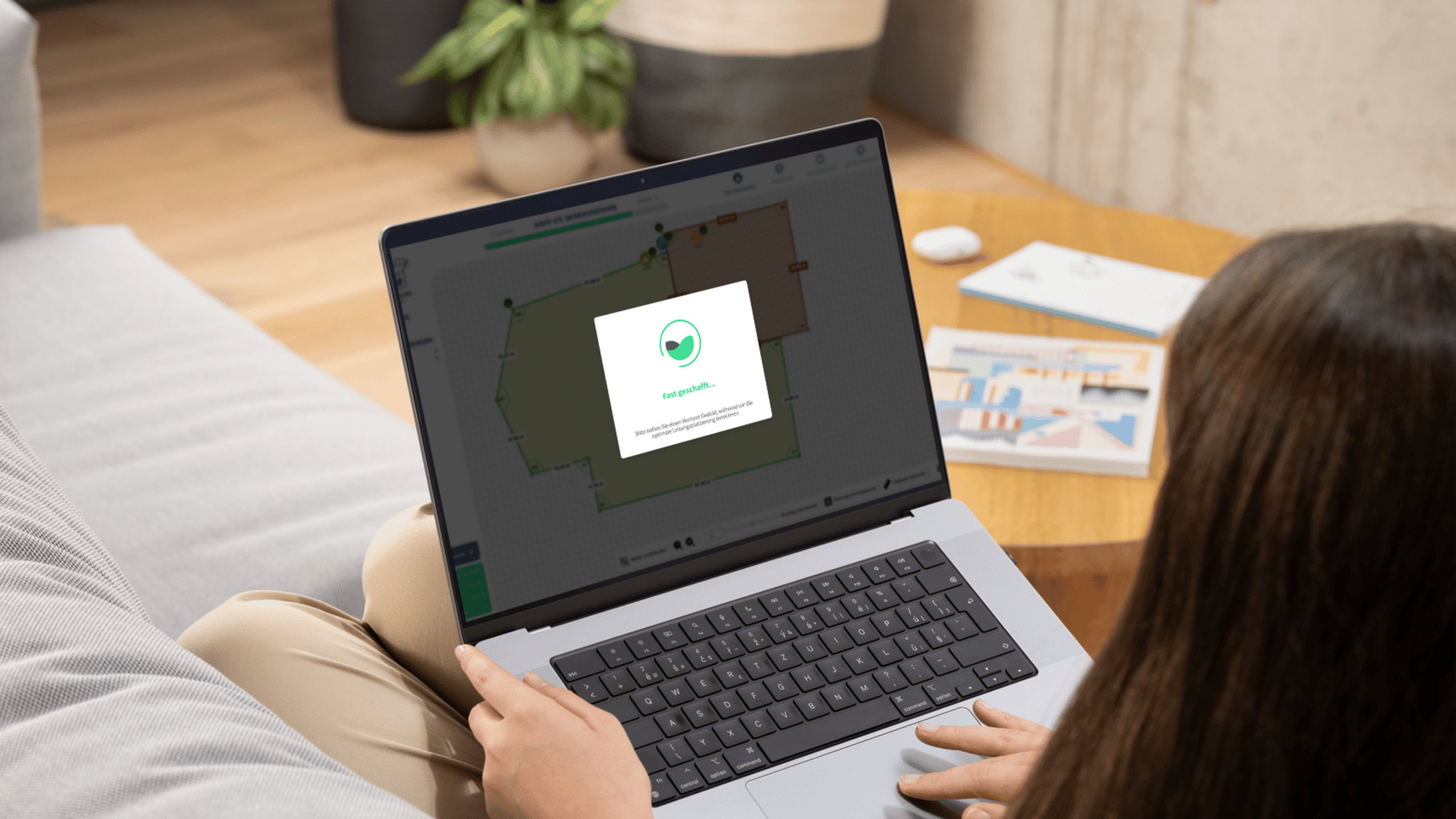 Frau plant automatisches Bewässerungssystem bequem online am Laptop mit digitalem Gartenplan